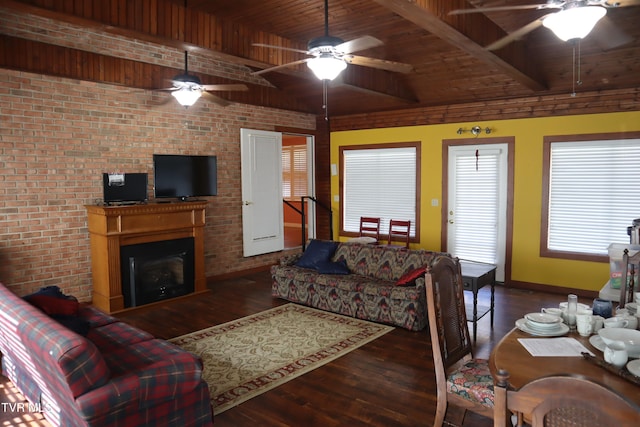 living room featuring beam ceiling, wooden ceiling, brick wall, dark hardwood / wood-style flooring, and ceiling fan