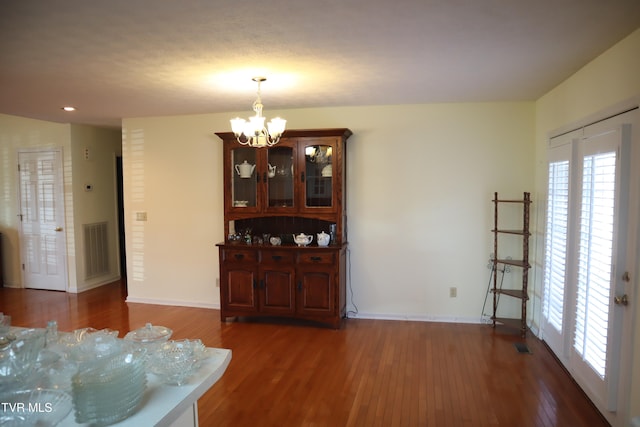 dining room featuring dark wood-type flooring and a notable chandelier