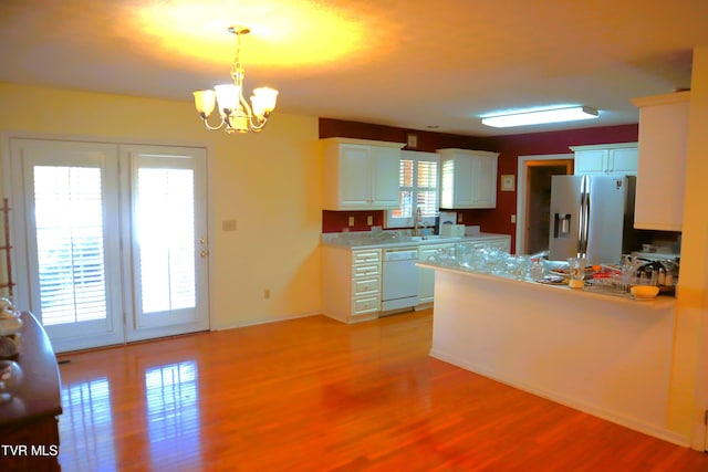 kitchen with white cabinetry, stainless steel fridge, dishwasher, and a wealth of natural light