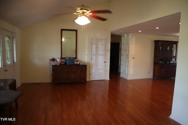 interior space with ceiling fan, lofted ceiling, and dark hardwood / wood-style flooring