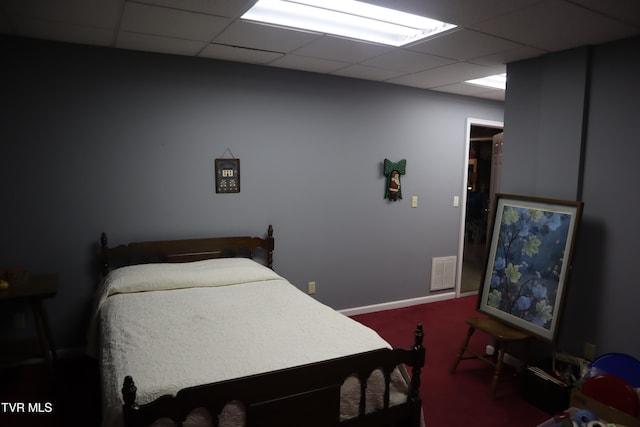 carpeted bedroom with a paneled ceiling