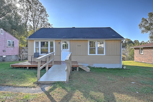 rear view of property featuring a deck and a lawn