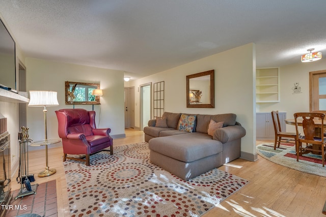 living room featuring light hardwood / wood-style floors and a textured ceiling