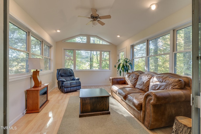 living room featuring ceiling fan, vaulted ceiling, and light wood-type flooring