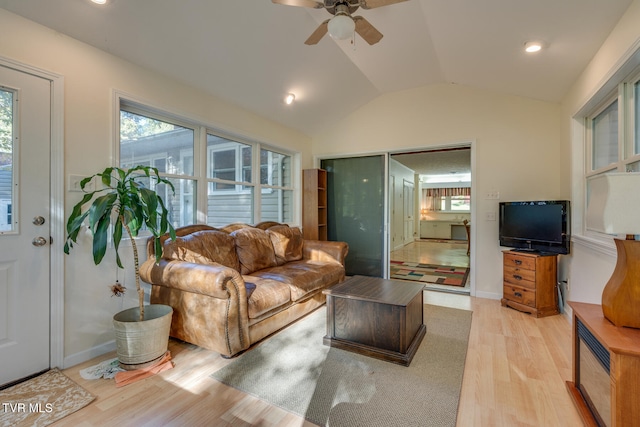 living room with light hardwood / wood-style flooring, lofted ceiling, and ceiling fan