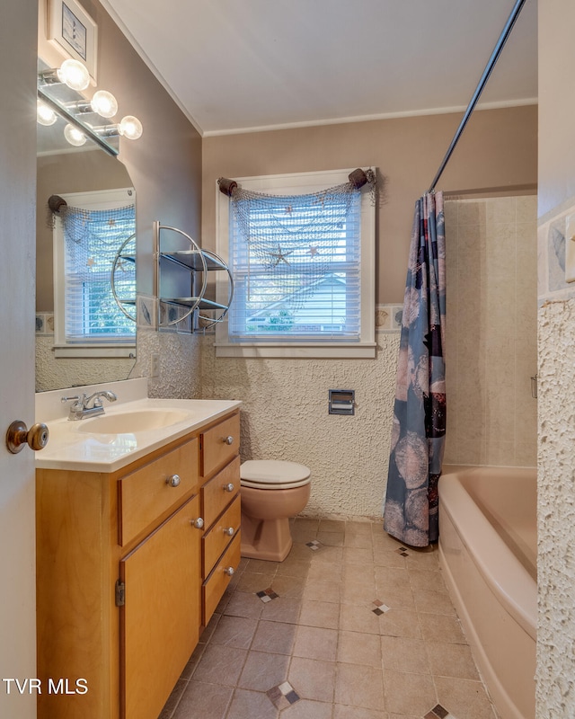 full bathroom featuring tile patterned floors, shower / bath combo, toilet, ornamental molding, and vanity