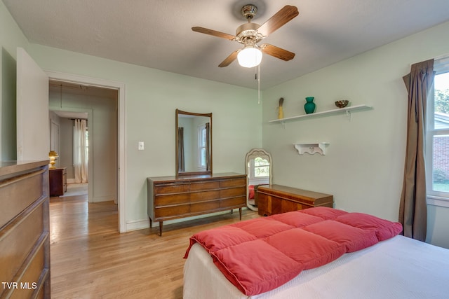 bedroom with ceiling fan, a textured ceiling, and light hardwood / wood-style flooring