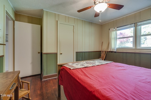bedroom featuring dark hardwood / wood-style flooring, ornamental molding, a textured ceiling, and ceiling fan