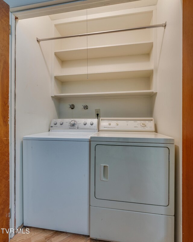laundry area with light wood-type flooring and separate washer and dryer