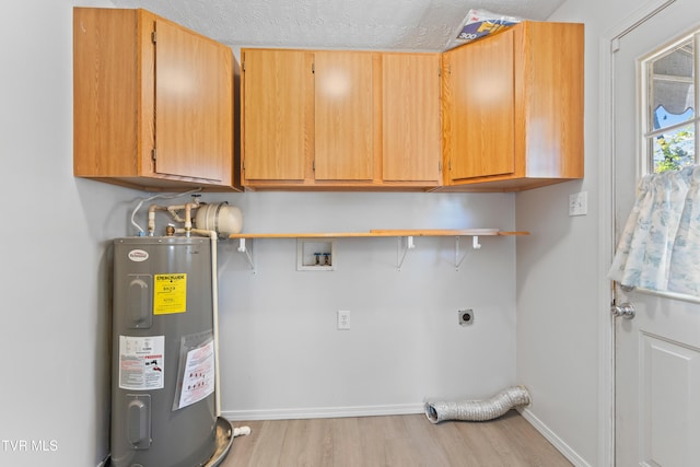 clothes washing area featuring water heater, cabinets, light hardwood / wood-style floors, electric dryer hookup, and a textured ceiling