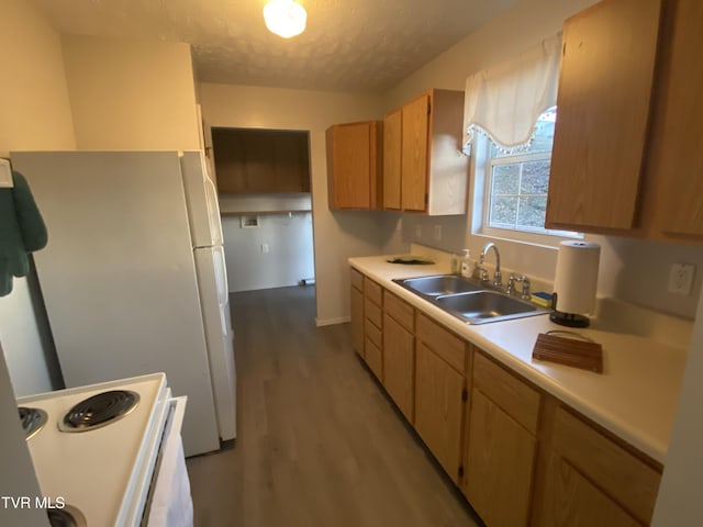 kitchen featuring sink, white appliances, light hardwood / wood-style flooring, and a textured ceiling