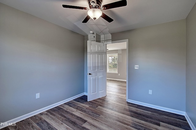 empty room featuring ceiling fan and dark wood-type flooring