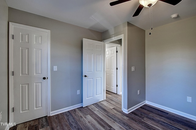 unfurnished bedroom featuring ceiling fan and dark wood-type flooring