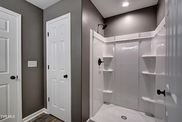 bathroom featuring hardwood / wood-style flooring and walk in shower