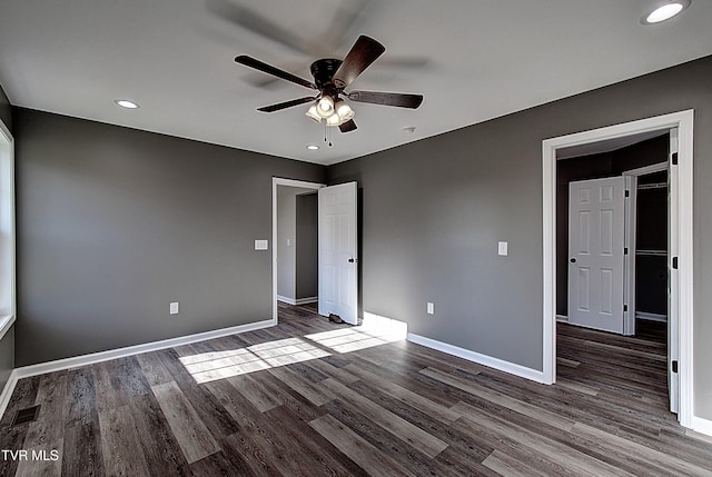 unfurnished bedroom featuring ceiling fan and dark hardwood / wood-style flooring