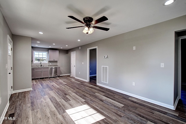 unfurnished living room featuring ceiling fan, sink, and hardwood / wood-style flooring