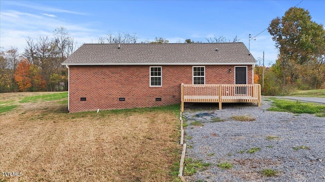 back of property with a lawn and a wooden deck