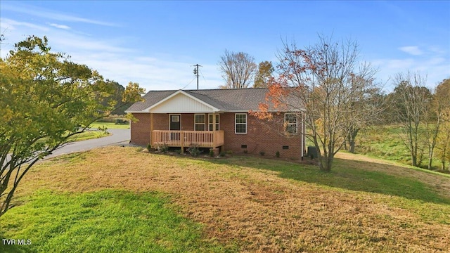 view of front of house with a deck and a front lawn