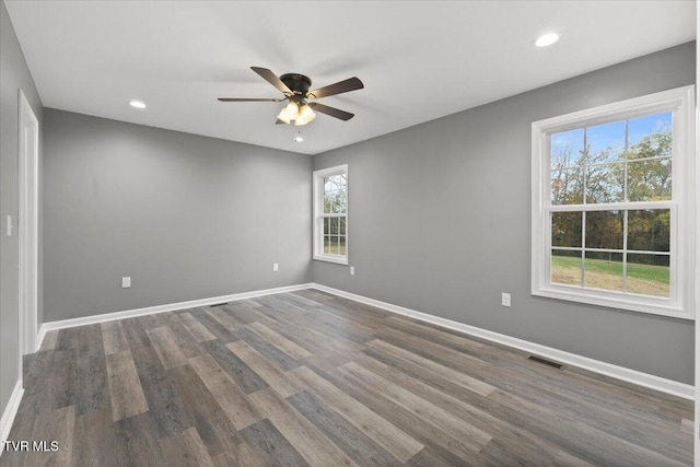 unfurnished room with ceiling fan and dark wood-type flooring