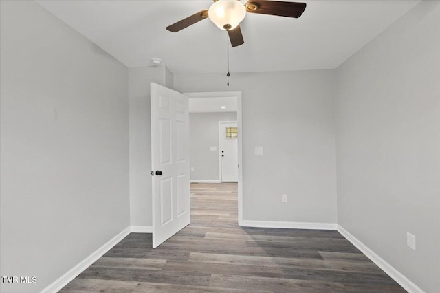 spare room with ceiling fan and dark wood-type flooring