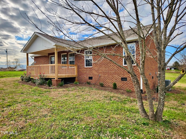 rear view of property featuring a lawn, a wooden deck, and central air condition unit