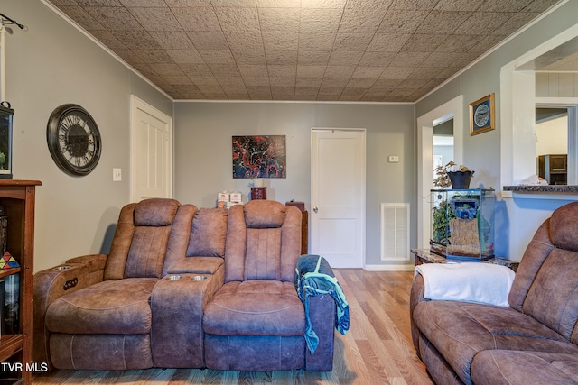 living room with light hardwood / wood-style flooring and crown molding