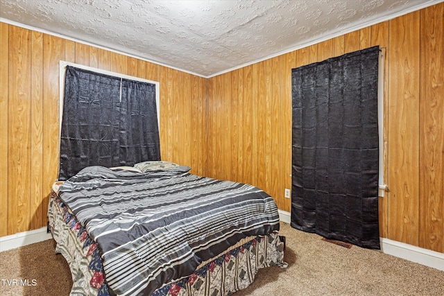 bedroom with a textured ceiling, carpet floors, and wood walls