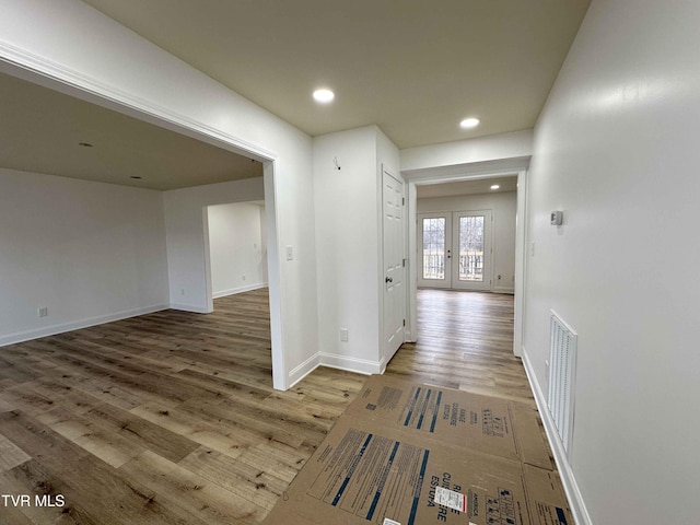 corridor featuring baseboards, visible vents, wood finished floors, french doors, and recessed lighting