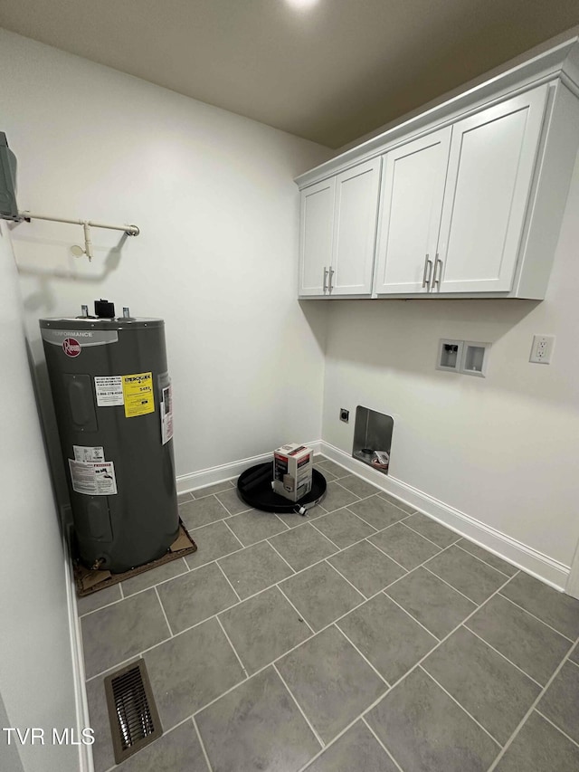 laundry area featuring water heater, dark tile patterned floors, cabinets, washer hookup, and hookup for an electric dryer