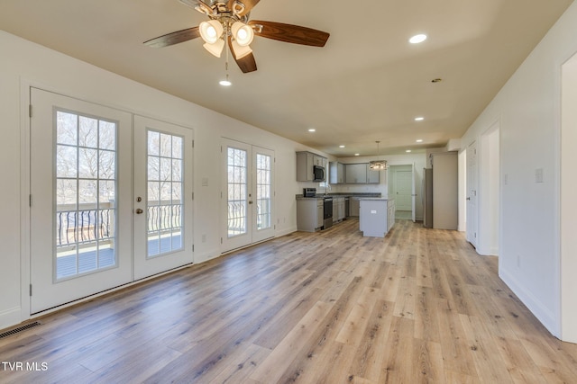 unfurnished living room featuring recessed lighting, french doors, visible vents, and light wood finished floors