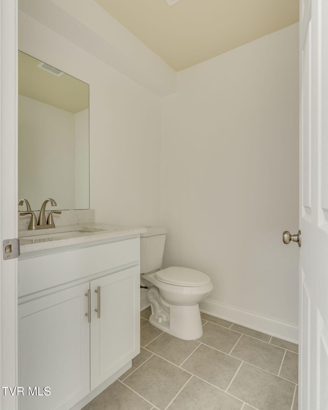 bathroom featuring tile patterned floors, visible vents, toilet, baseboards, and vanity