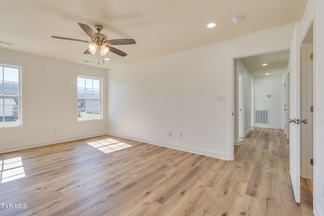 unfurnished room featuring light wood-type flooring, visible vents, baseboards, and recessed lighting