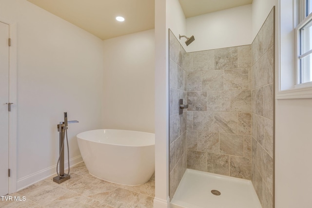 bathroom with a soaking tub, recessed lighting, baseboards, and tiled shower