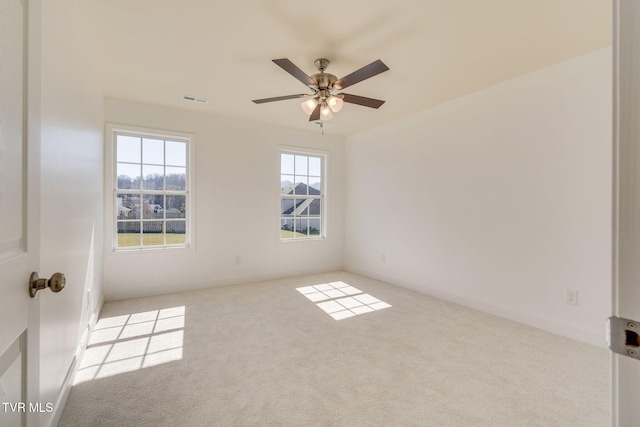 spare room featuring carpet flooring, baseboards, visible vents, and ceiling fan