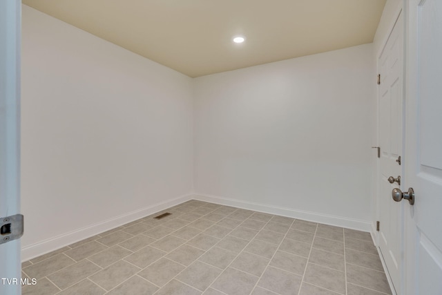 spare room featuring recessed lighting and baseboards