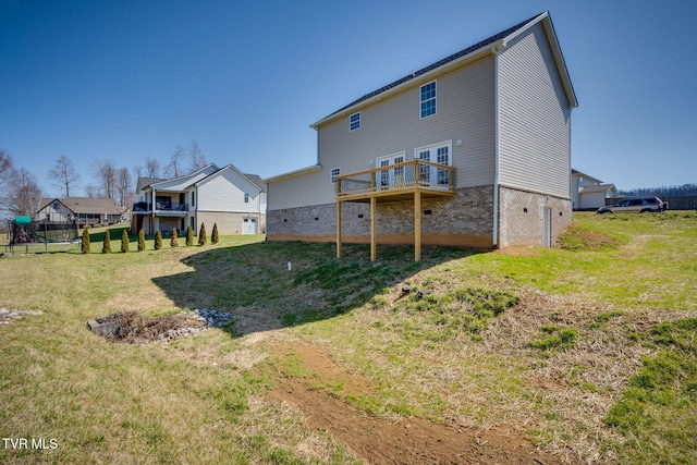 back of property featuring a deck and a lawn