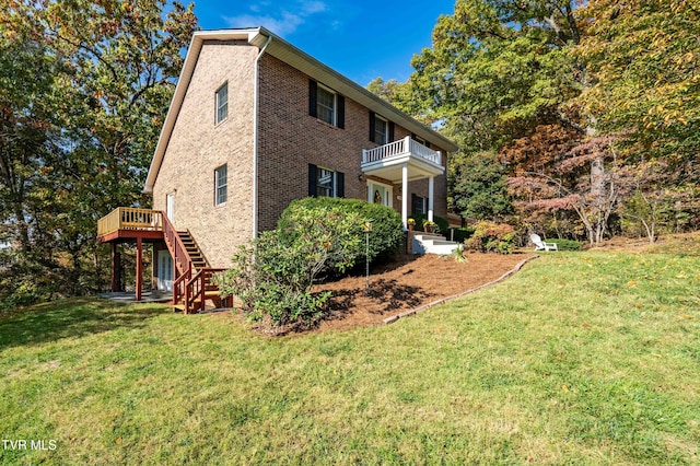 view of side of home featuring a lawn and a balcony