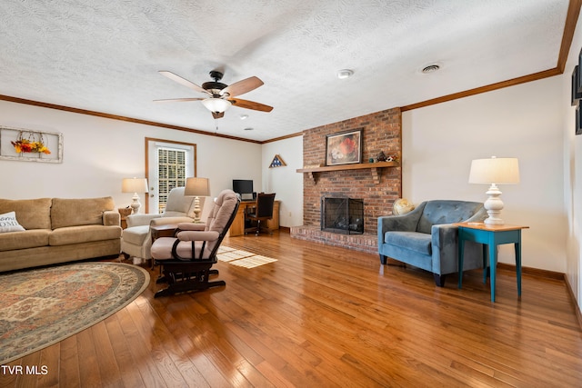 living room with a textured ceiling, wood-type flooring, and a brick fireplace