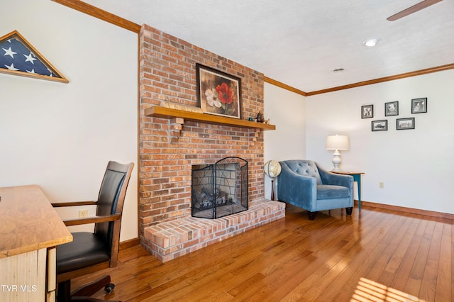 unfurnished office with hardwood / wood-style floors, crown molding, a fireplace, and a textured ceiling