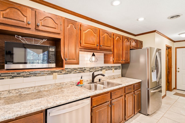 kitchen featuring light tile patterned floors, appliances with stainless steel finishes, light stone countertops, crown molding, and sink