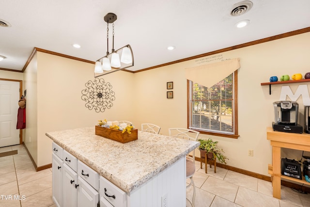 kitchen with a kitchen island, ornamental molding, decorative light fixtures, light tile patterned floors, and white cabinetry