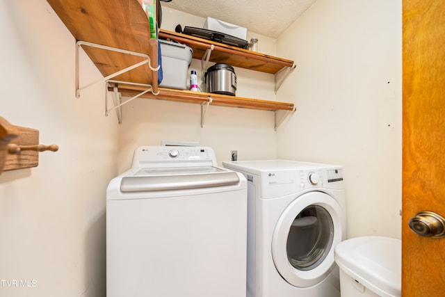 clothes washing area with a textured ceiling, sink, and washing machine and dryer