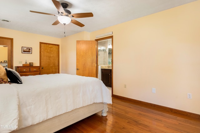 bedroom with connected bathroom, ceiling fan, and wood-type flooring