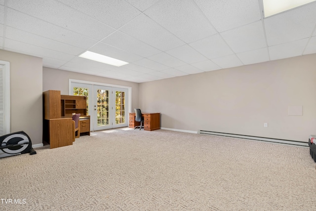 basement featuring french doors, a baseboard heating unit, a drop ceiling, and carpet floors