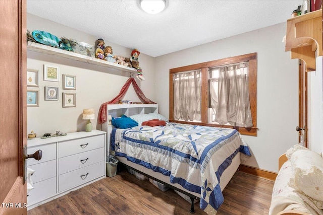 bedroom with dark wood-type flooring and a textured ceiling