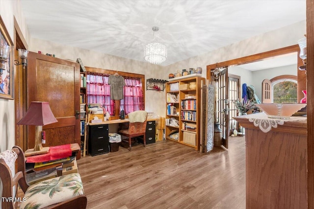 office space featuring an inviting chandelier and hardwood / wood-style floors