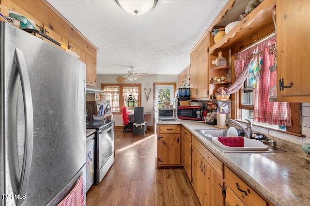 kitchen featuring sink, a textured ceiling, appliances with stainless steel finishes, hardwood / wood-style flooring, and ceiling fan