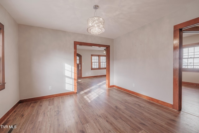 empty room featuring hardwood / wood-style floors and a notable chandelier