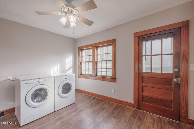 laundry room featuring hardwood / wood-style floors, washing machine and dryer, a textured ceiling, and ceiling fan