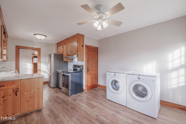 laundry room with ceiling fan, sink, separate washer and dryer, and light hardwood / wood-style floors